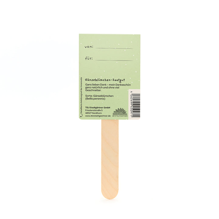 Rückseite eines grünen Samentütchens für Gänseblümchen mit Holzstab, Beschriftungsfeldern "von" und "für" sowie Produktinformationen auf Deutsch.