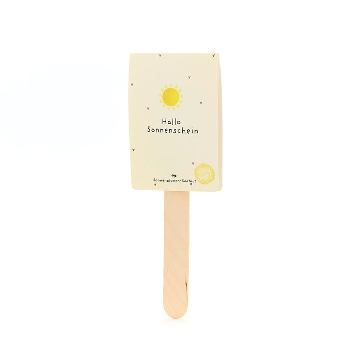 Holzstab mit einer gelben Karte, auf der "Hallo Sonnenschein" und eine Sonne abgebildet sind.