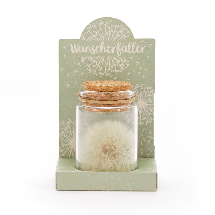 Glasfläschchen mit Löwenzahn-Pusteblume und Korken, auf grünem Karton mit der Aufschrift "Wunscherfüller".