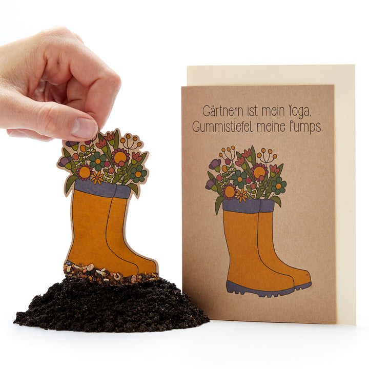 Blumengesteck in Gummistiefel-Form, daneben eine Karte mit der Aufschrift "Gärtnern ist mein Yoga, Gummistiefel meine Pumps."